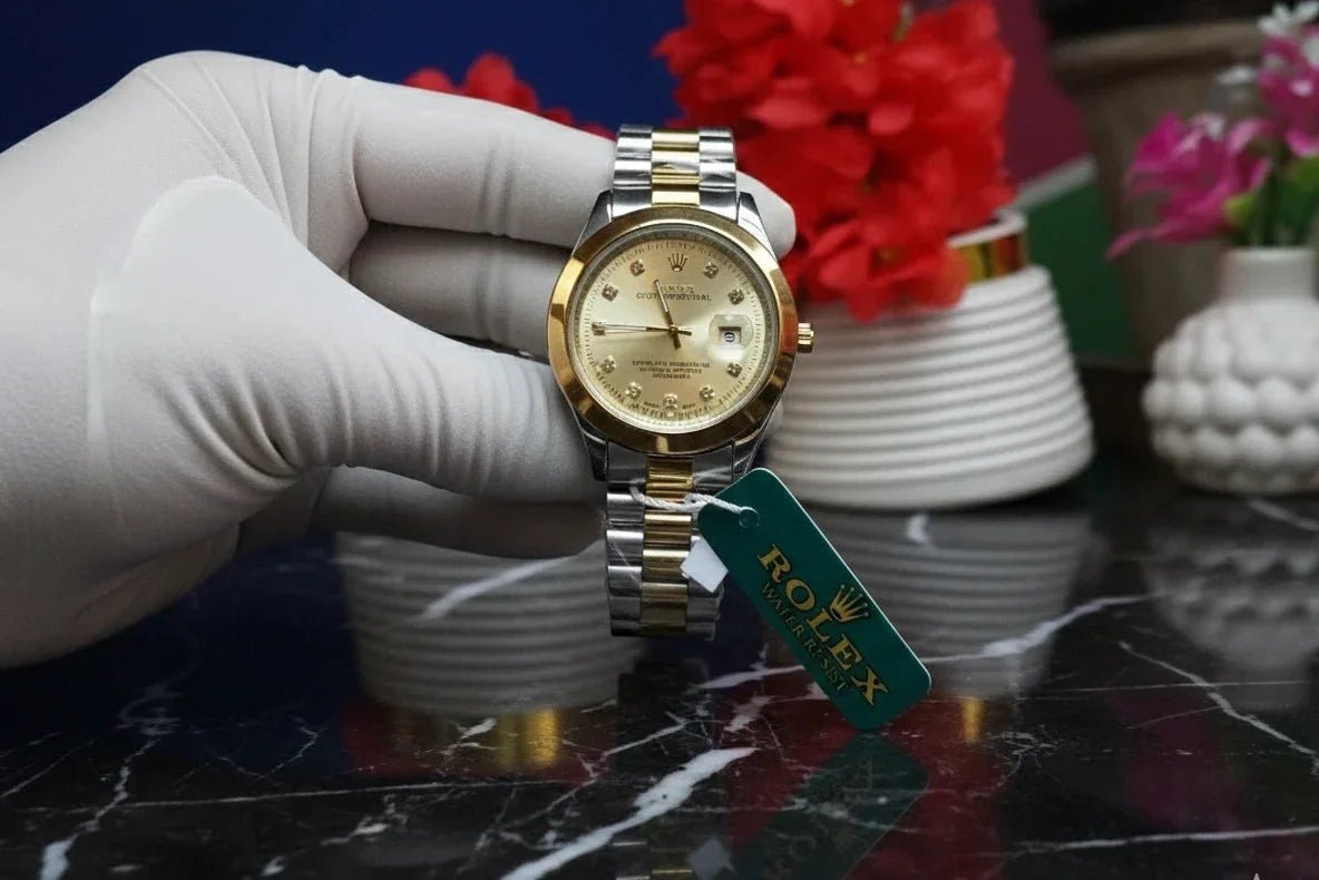 Gold watch held by a gloved hand with a blurred background