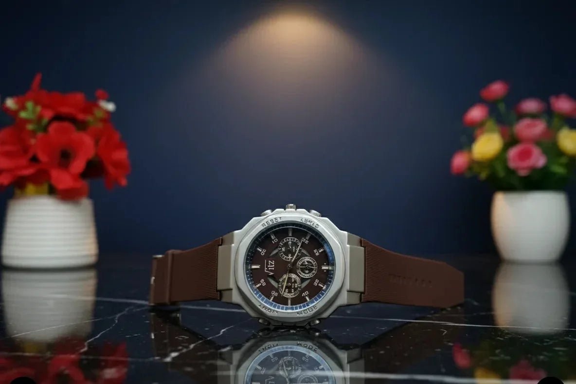 Luxury watch with brown leather strap on a reflective surface with flowers in the background