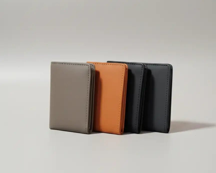 Three leather wallets in gray, brown, and black on a light gray background
