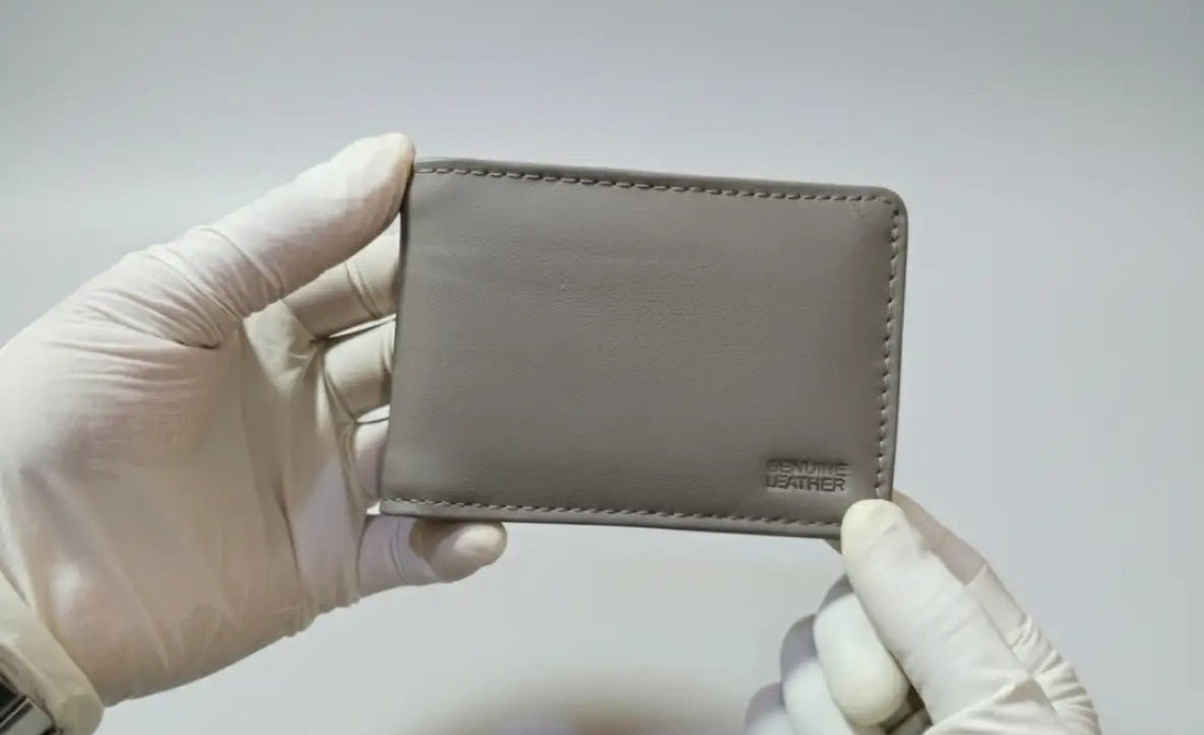 Hand holding a gray wallet with a blurred background