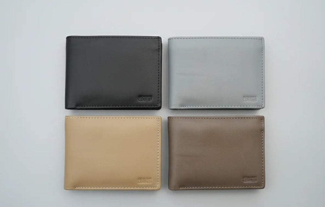 Four leather wallets in black, gray, beige, and brown on a light gray background.
