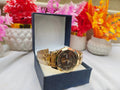 Gold wristwatch in a box with decorative flowers in the background