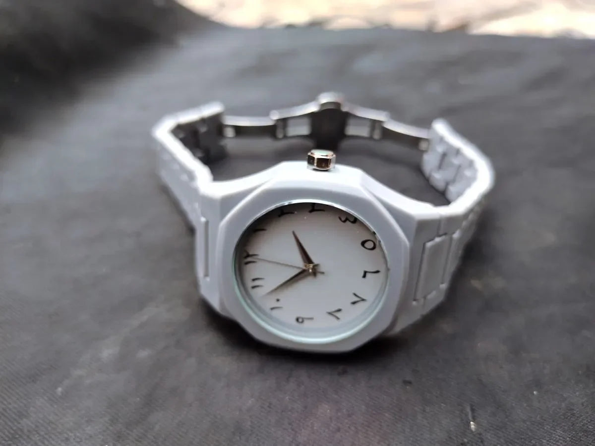 Silver watch with a white face on a dark surface