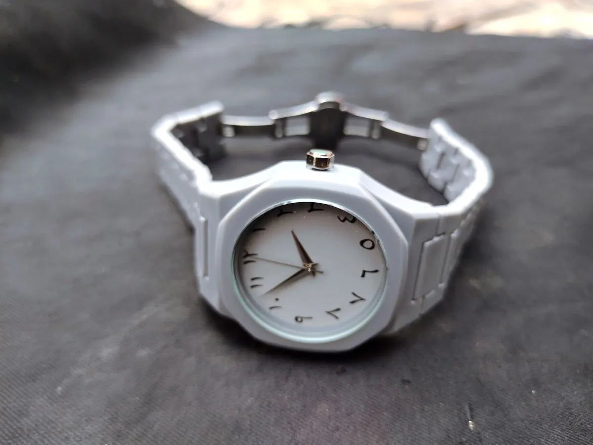 Silver watch with a white face on a dark surface