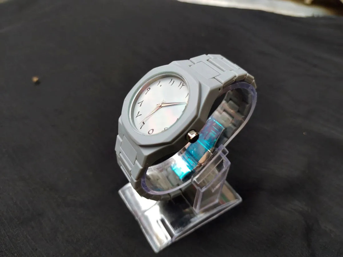 Person holding a watch with a neutral background