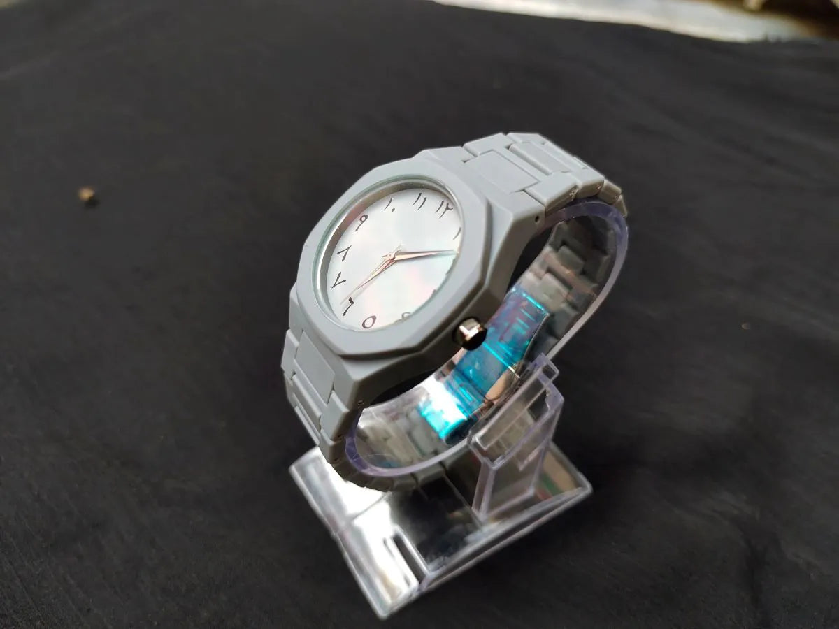 Gray watch with a unique design on a dark surface