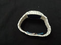 White ceramic bracelet with blue accents on a black background