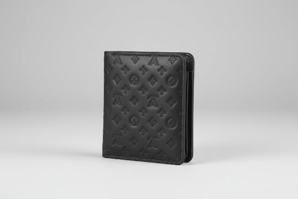 Black wallet with monogram pattern on a textured gray surface